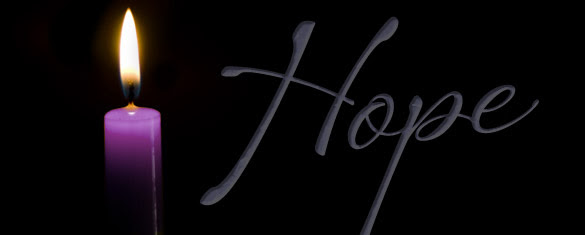 Lit advent candle of hope with the text "Hope".