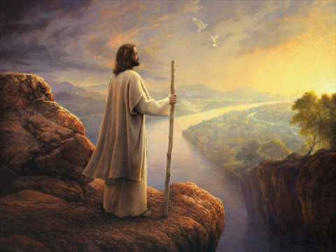 Image of Jesus in white robes with a staff standing on a cliff. He is in the shadow facing the rising sun.