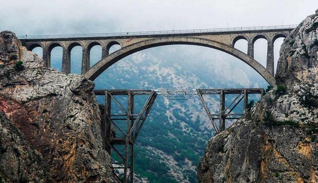 The image is of two twin bridges over a rather large canyon. The bridge in the background does not look to be completed.