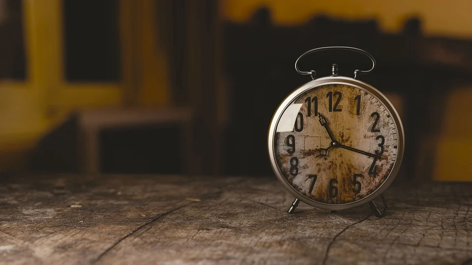 image of a rustic alarm clock on a wooden table.