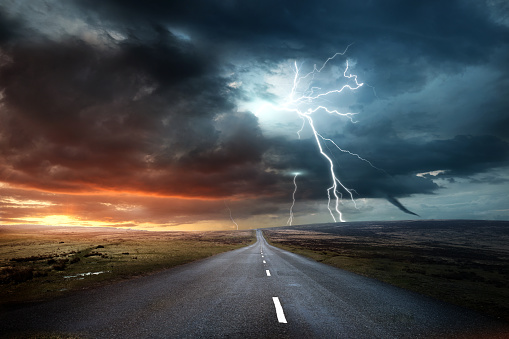 An image of a road with a storm up ahead.