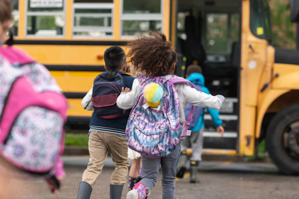 An image of children happily running to get on the bus. 