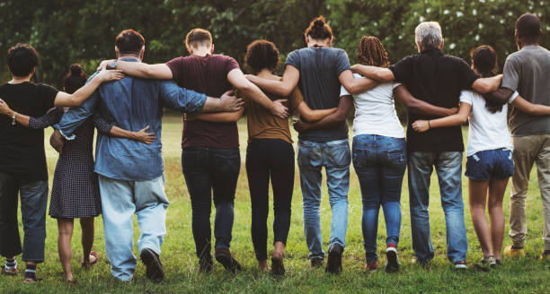 An image of a diverse group of people walking together. The image is taking from behind.